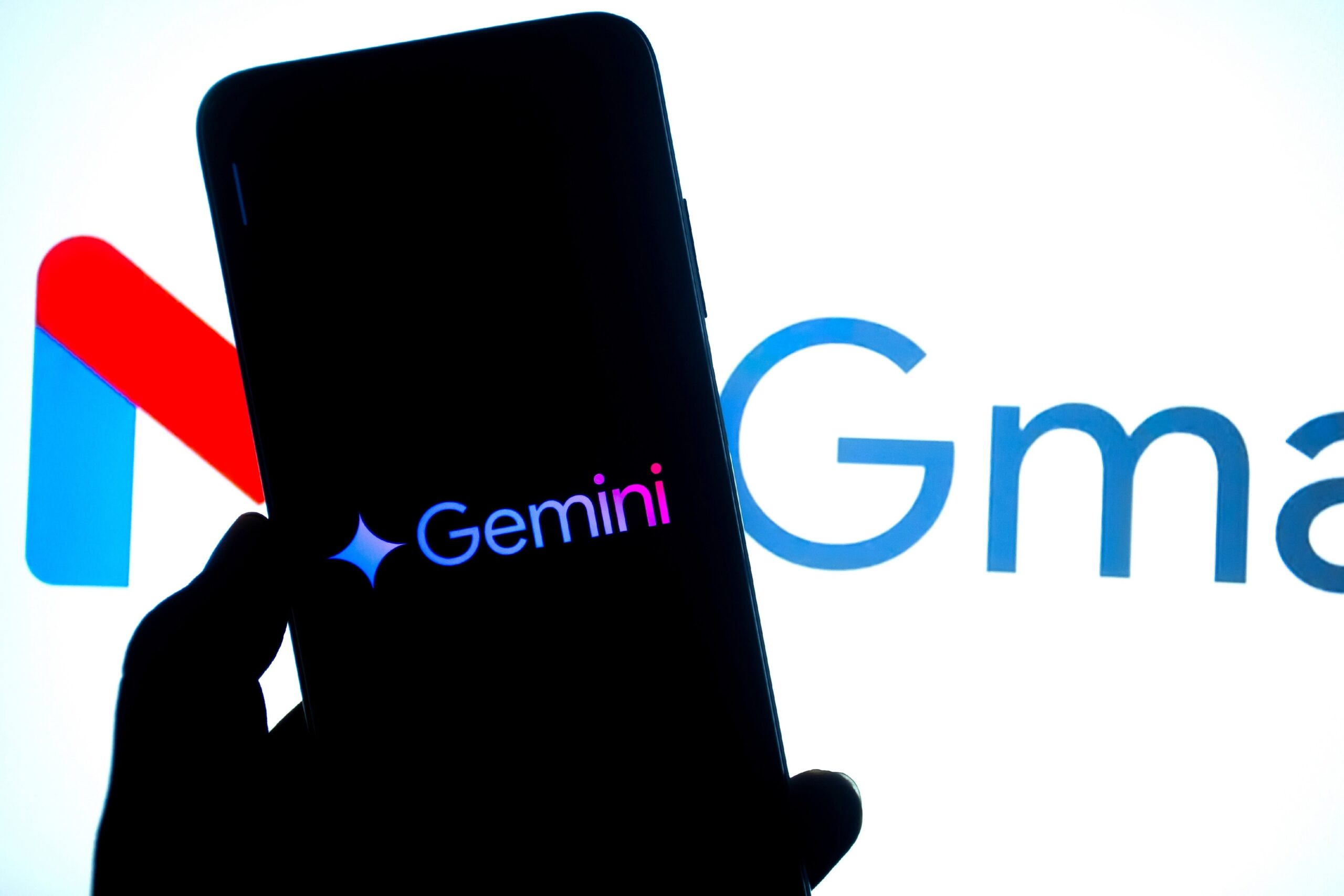 Gemini logo displayed on a smartphone with Gmail logo in the background