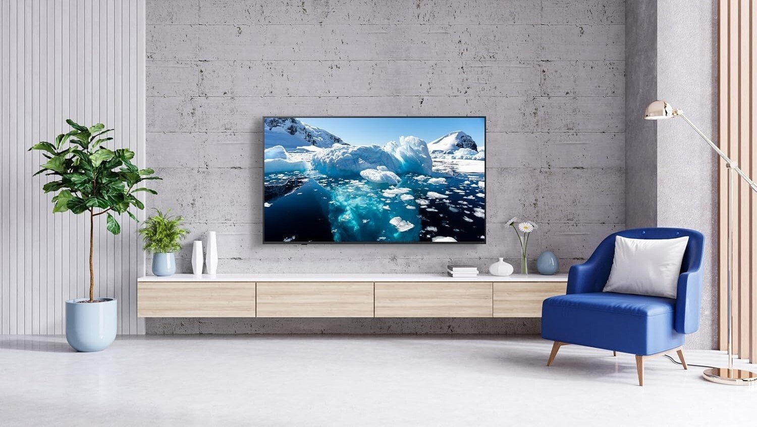 the LG 86-Inch Class QNED wall mounted in a living room with concrete walls and a blue chair off to the right side