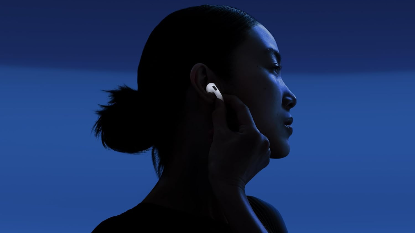 woman wearing AirPods 4 with blue background