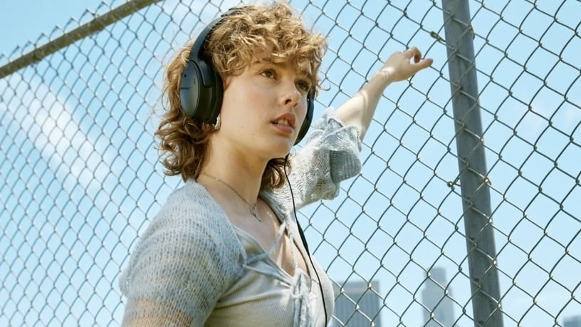person wearing bose quietcomfort headphones outside and looking out into the distance