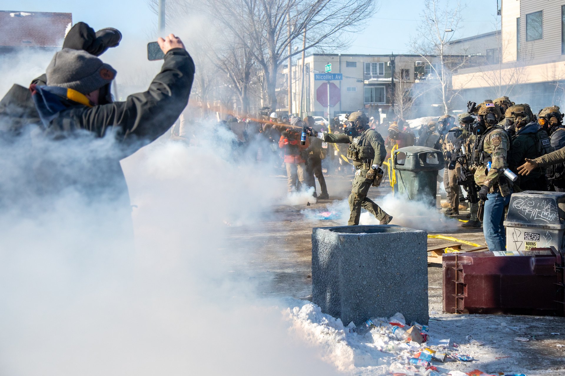 Man holds up a phone during a clash between protesters and authorities in Minneapolis. 