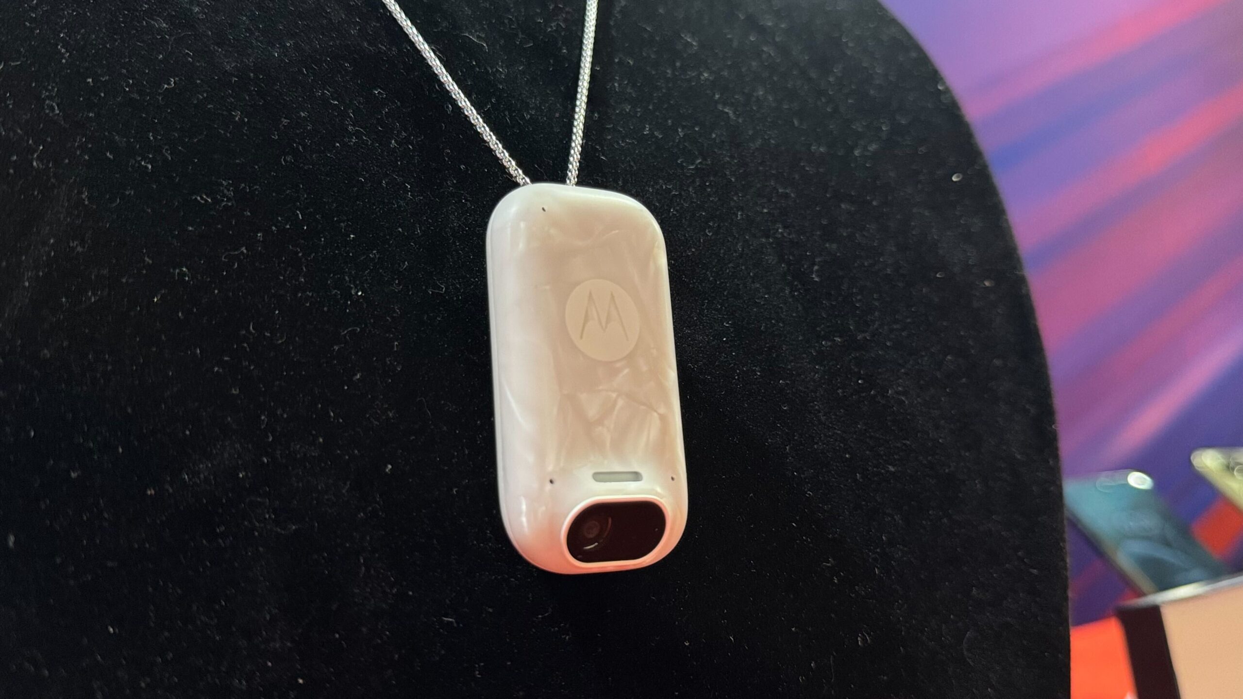 white wearable AI device on black background