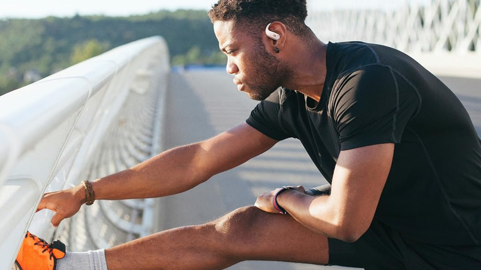 man stretching wearing JBL Endurance Zone earbuds