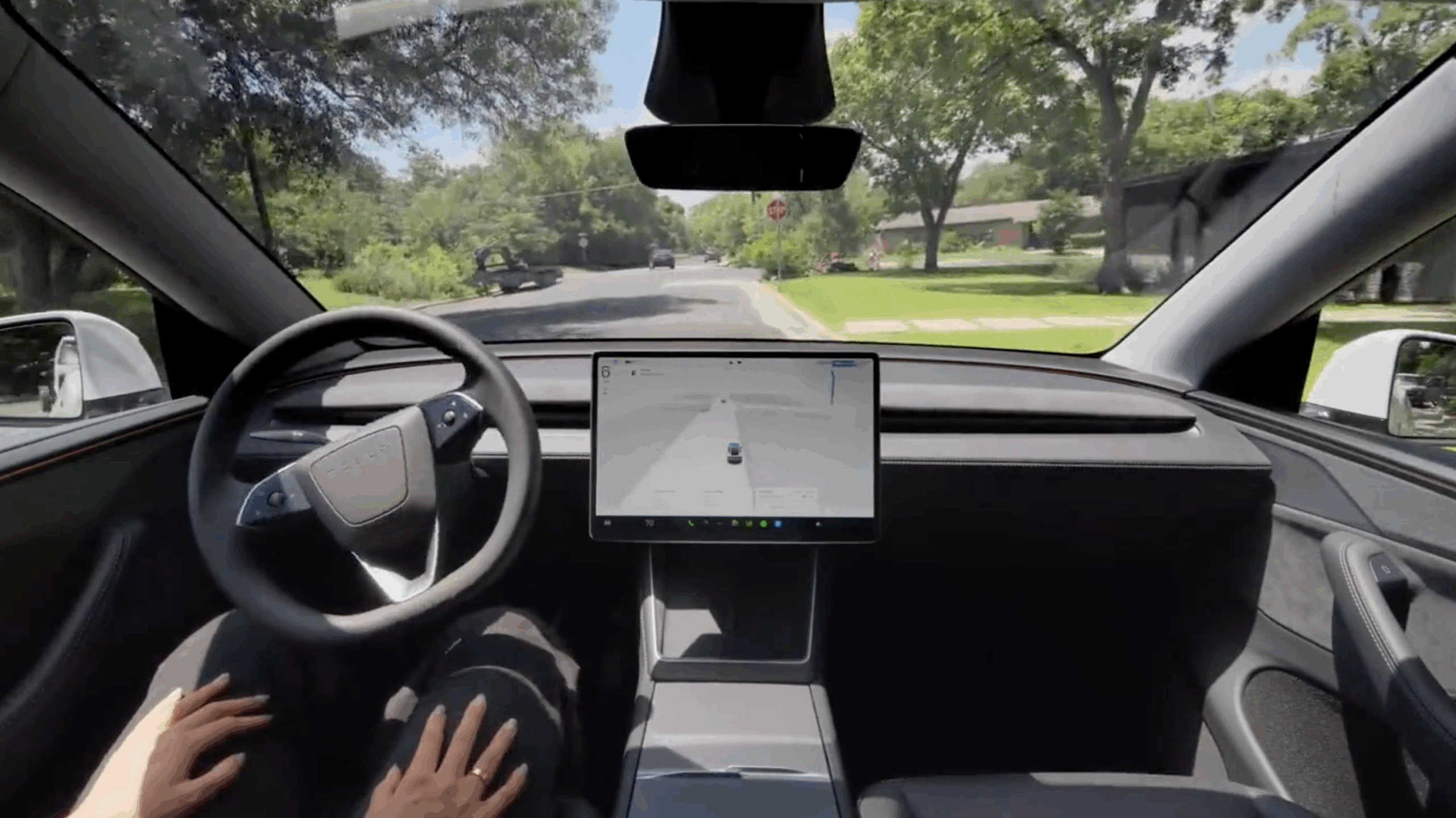 Inside a Tesla, a driver uses Full Self Driving.