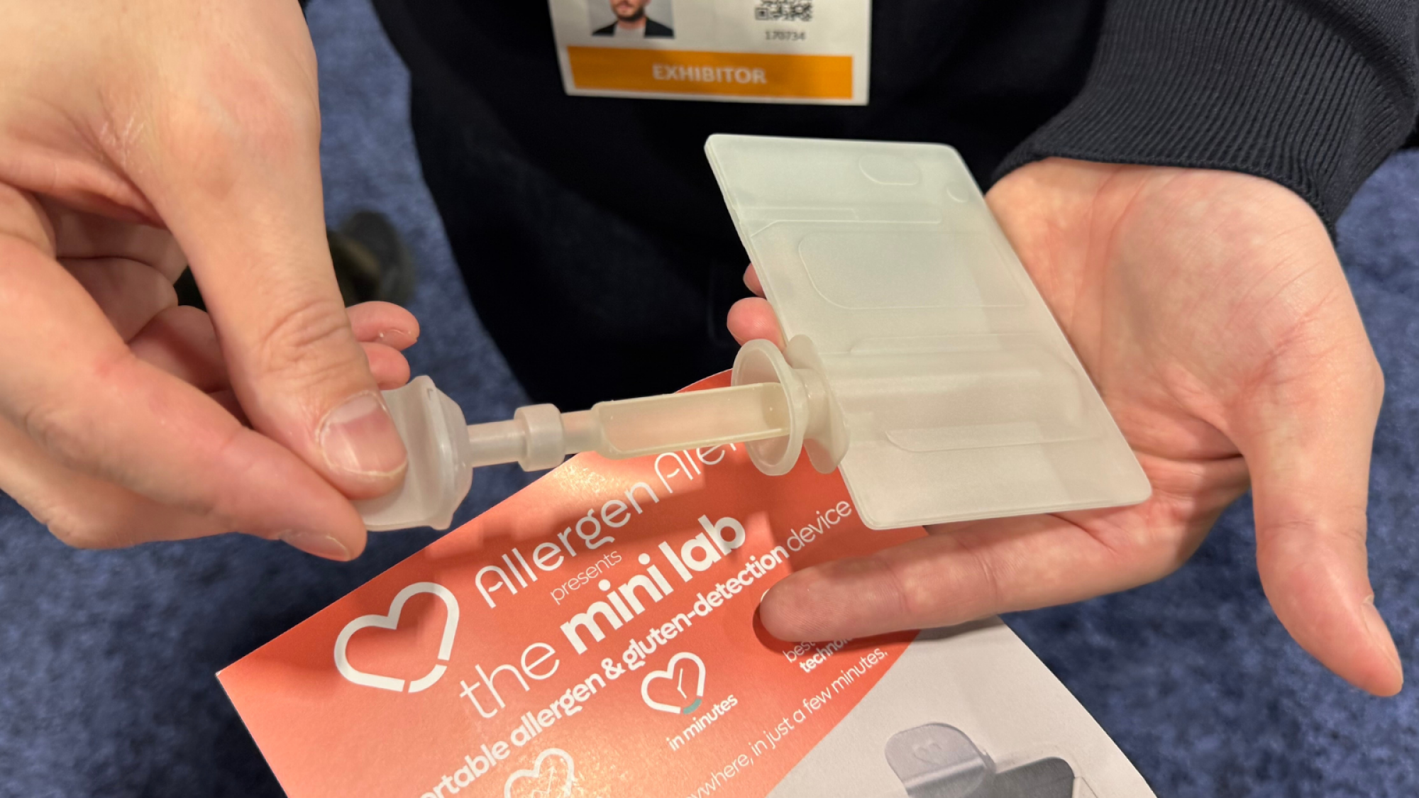 A close-up of the Allergen Alert mini lab's single-use pouch and scooper