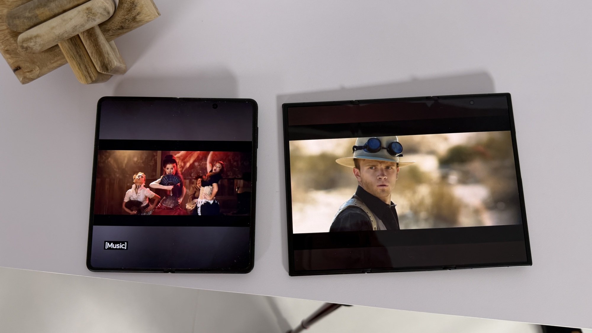 Two trifold phones, one completely opened and the other partially opened.