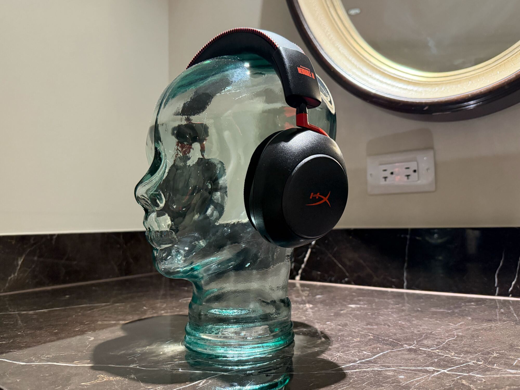 Glass head bust wearing chunky black headphones