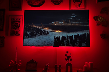 "Game of Thrones" scene on wall-mounted TCL QM6K TV with red light glowing around edges