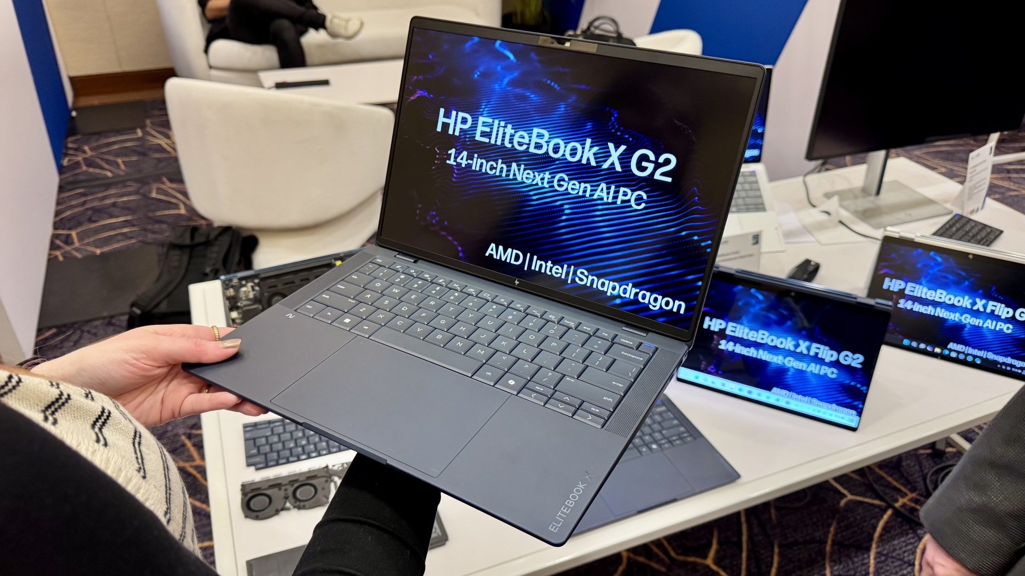 a woman holding an HP EliteBook X G2 laptop at ces 2026