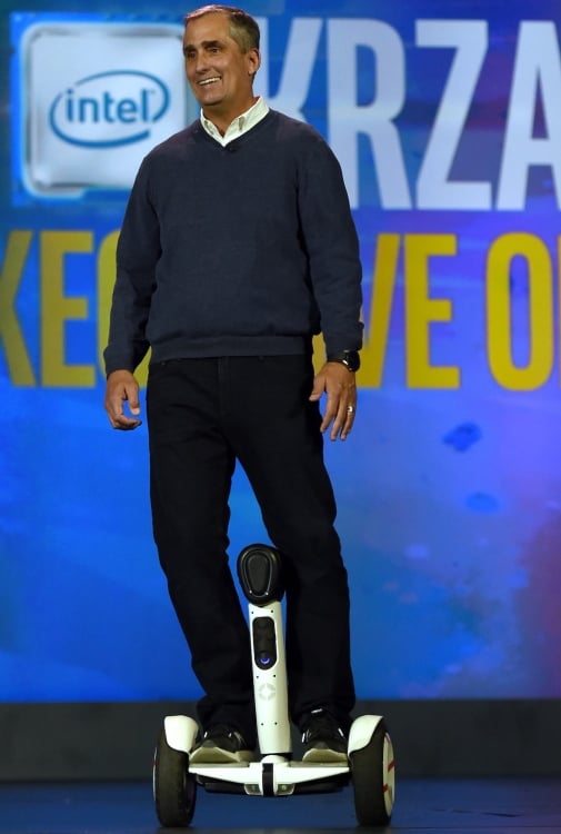 A man in a sweater riding a scooter robot