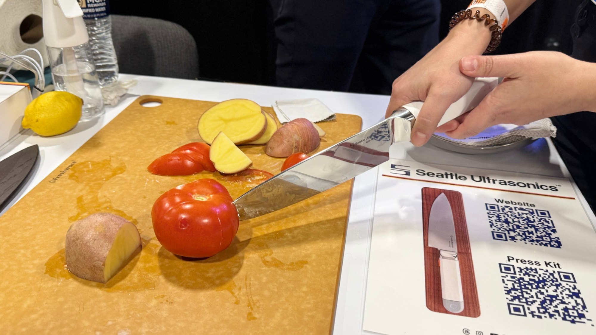 a woman slicing a tomato with the Seattle Ultrasonics C-200 UltraSonic Chef's Knife