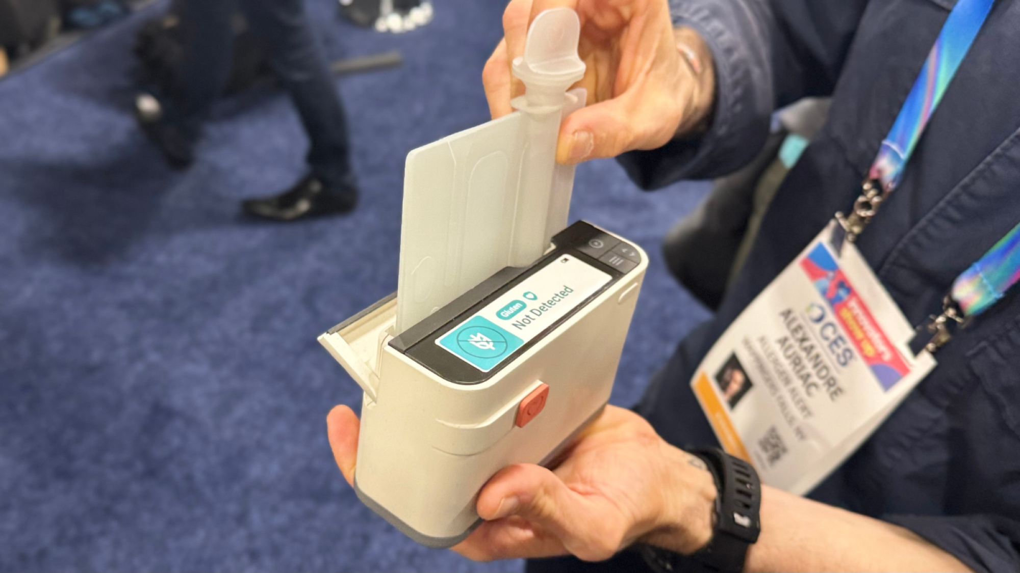 A close-up of a man holding the Allergen Alert mini lab.