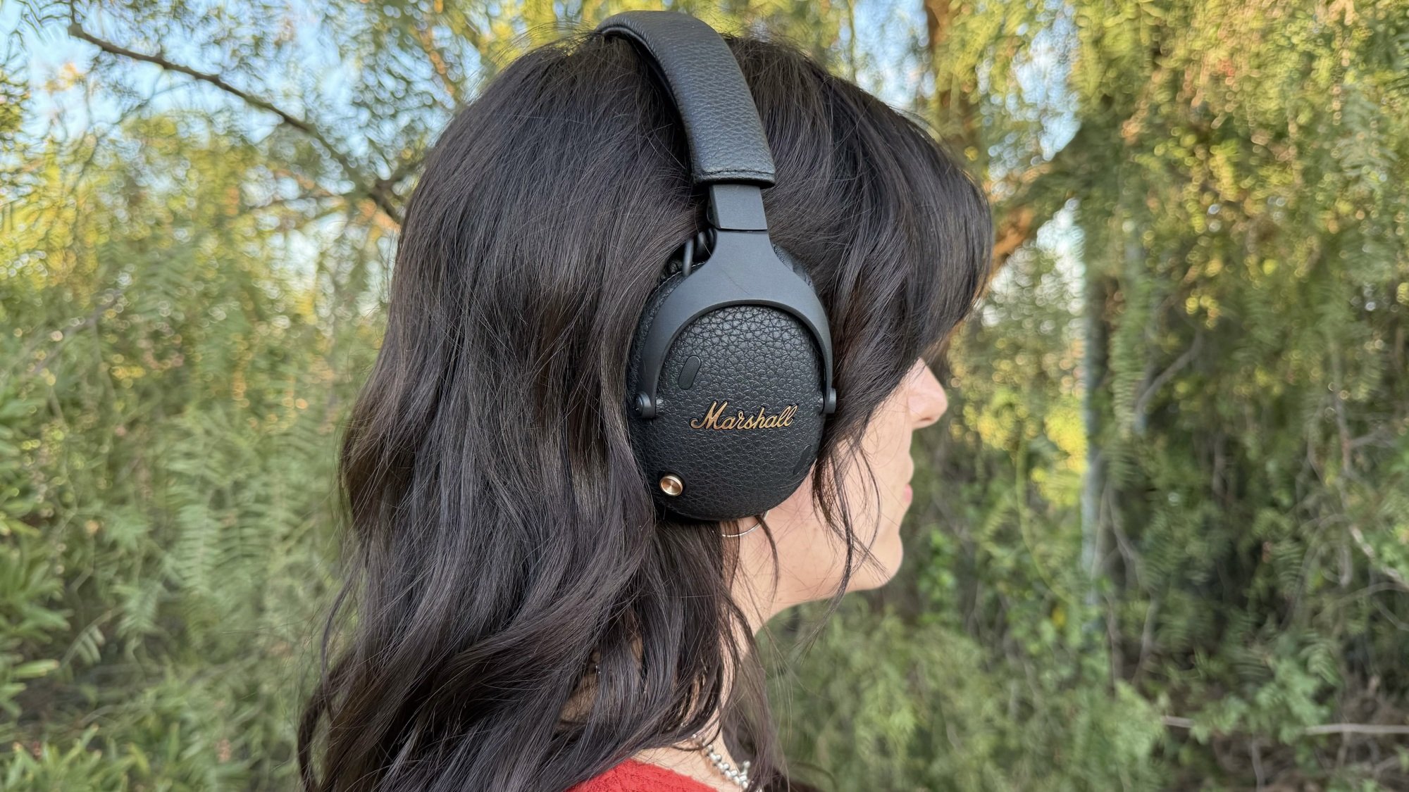 woman standing outside wearing marshall monitor iii headphones