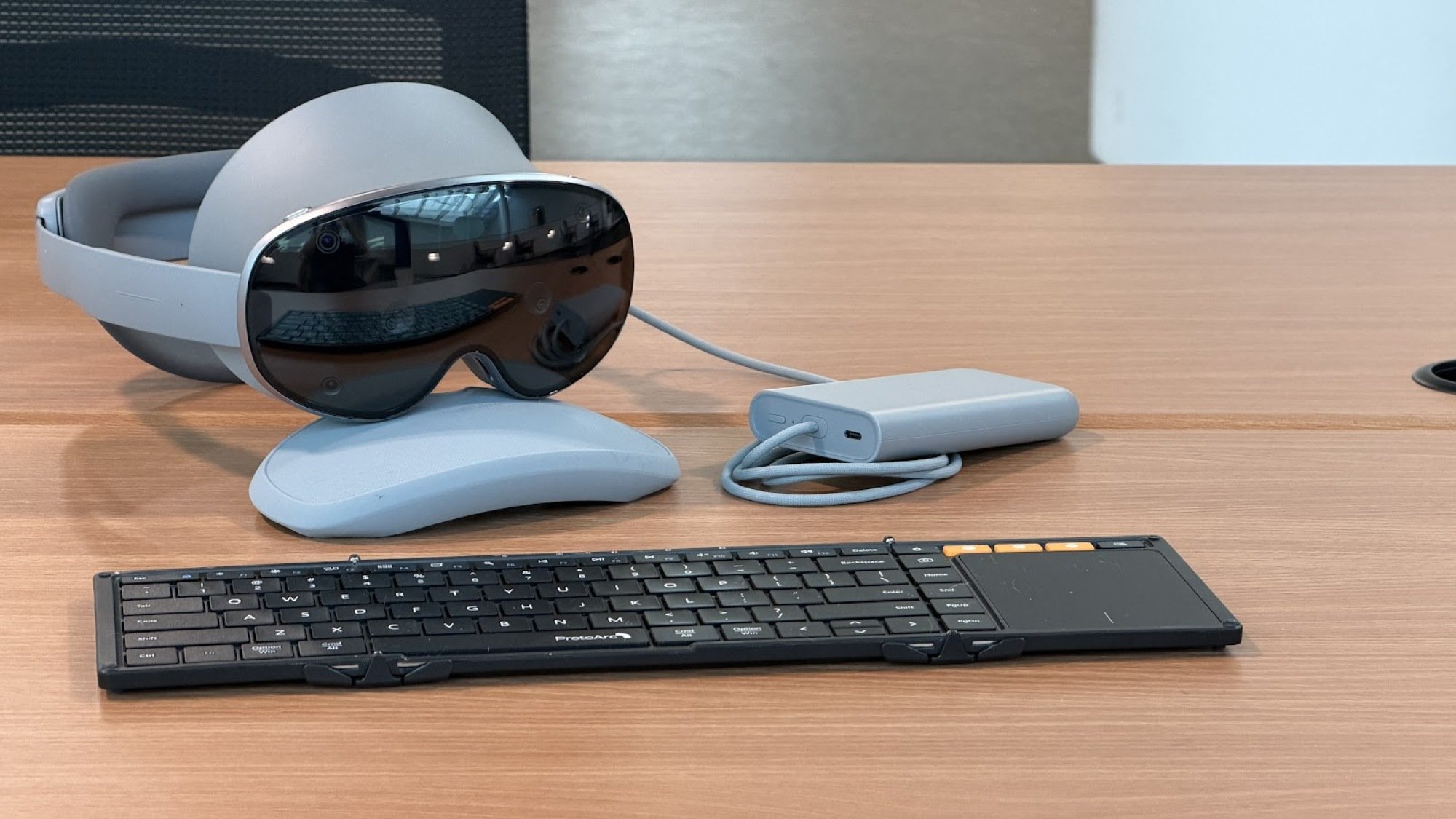Galaxy XR headset sits on a table with a charging dock and keyboard