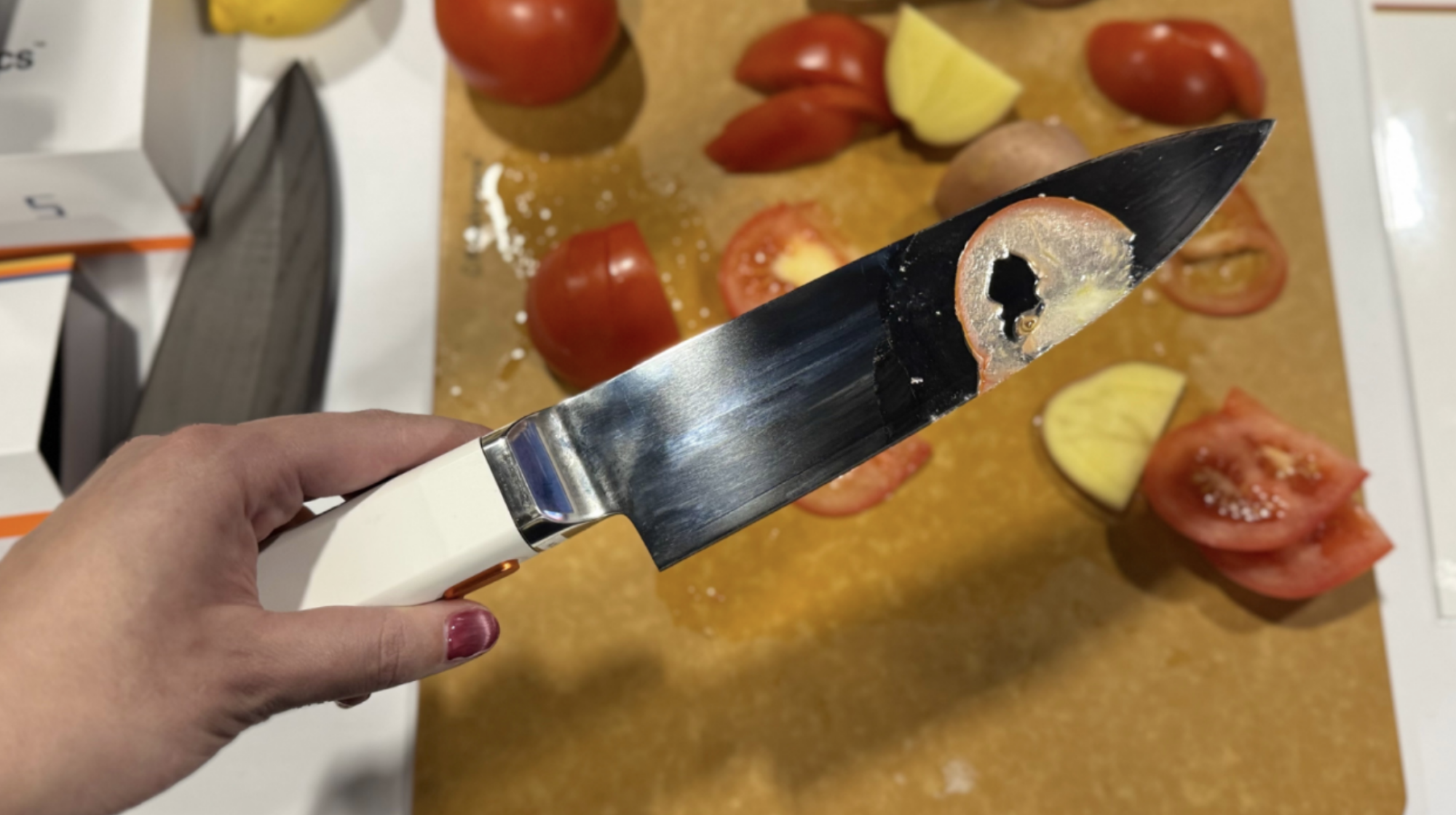 a knife with a super thing slice of tomato
