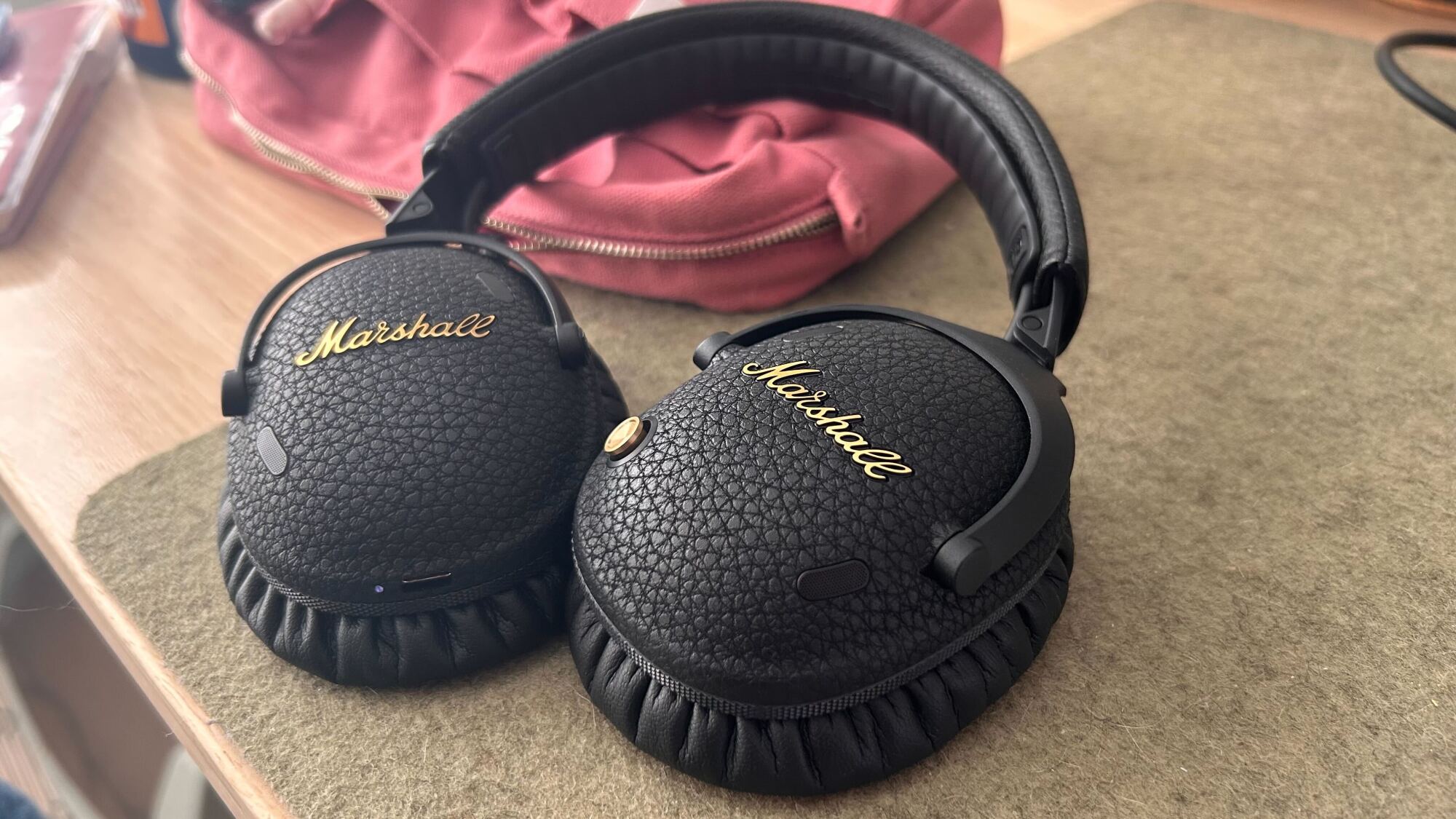 marshall headphones on green desk mat leaning against pink pouch