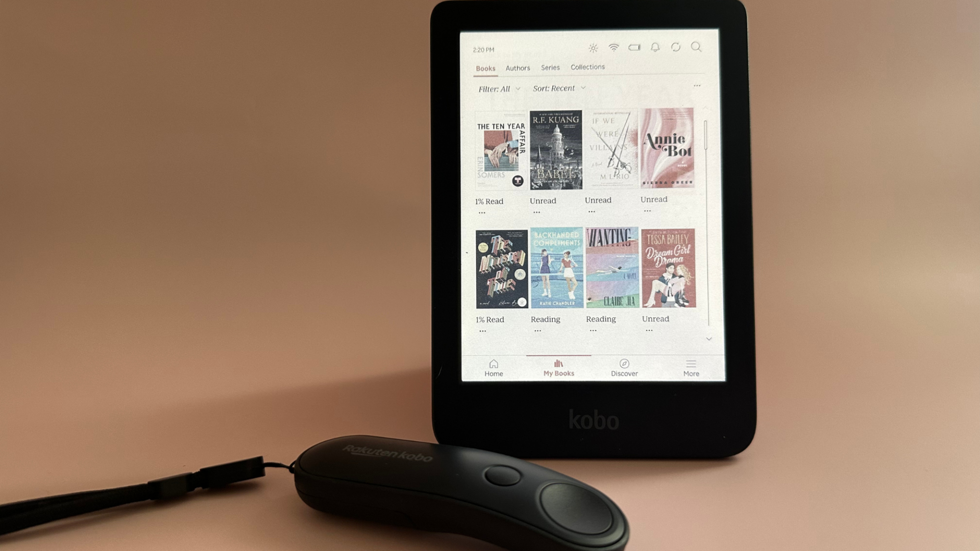 A Kobo Clara Colour and Kobo remote on a pale pink background.