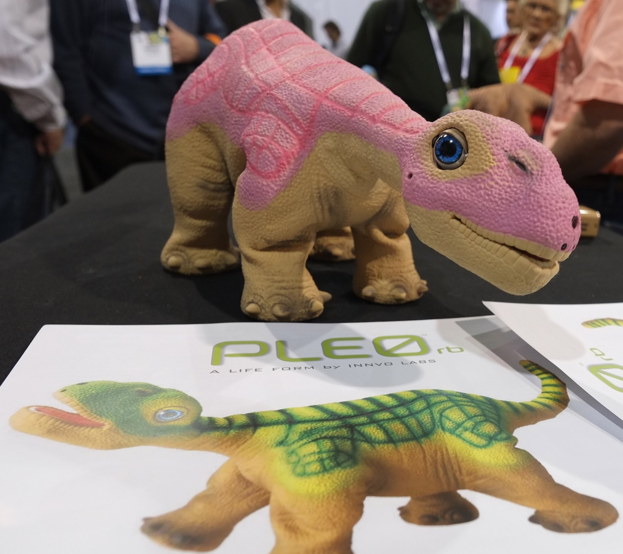 A pink dinosaur robot above a box that says Pleo