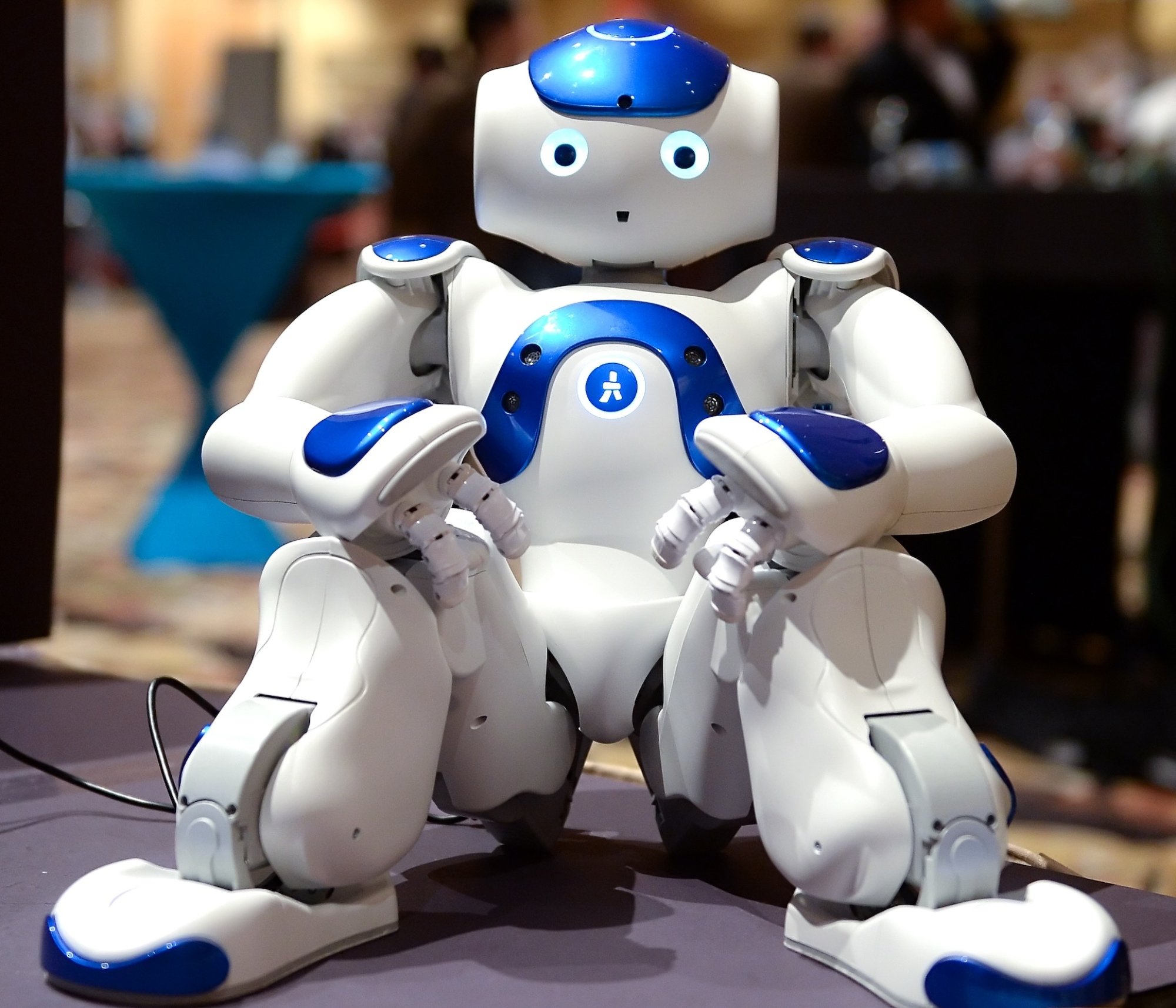 A robot sits legs akimbo at CES.