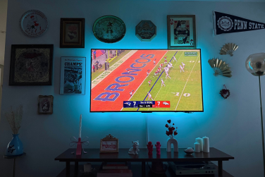 NFL game on wall-mounted TCL QM6K TV with blue glow around border