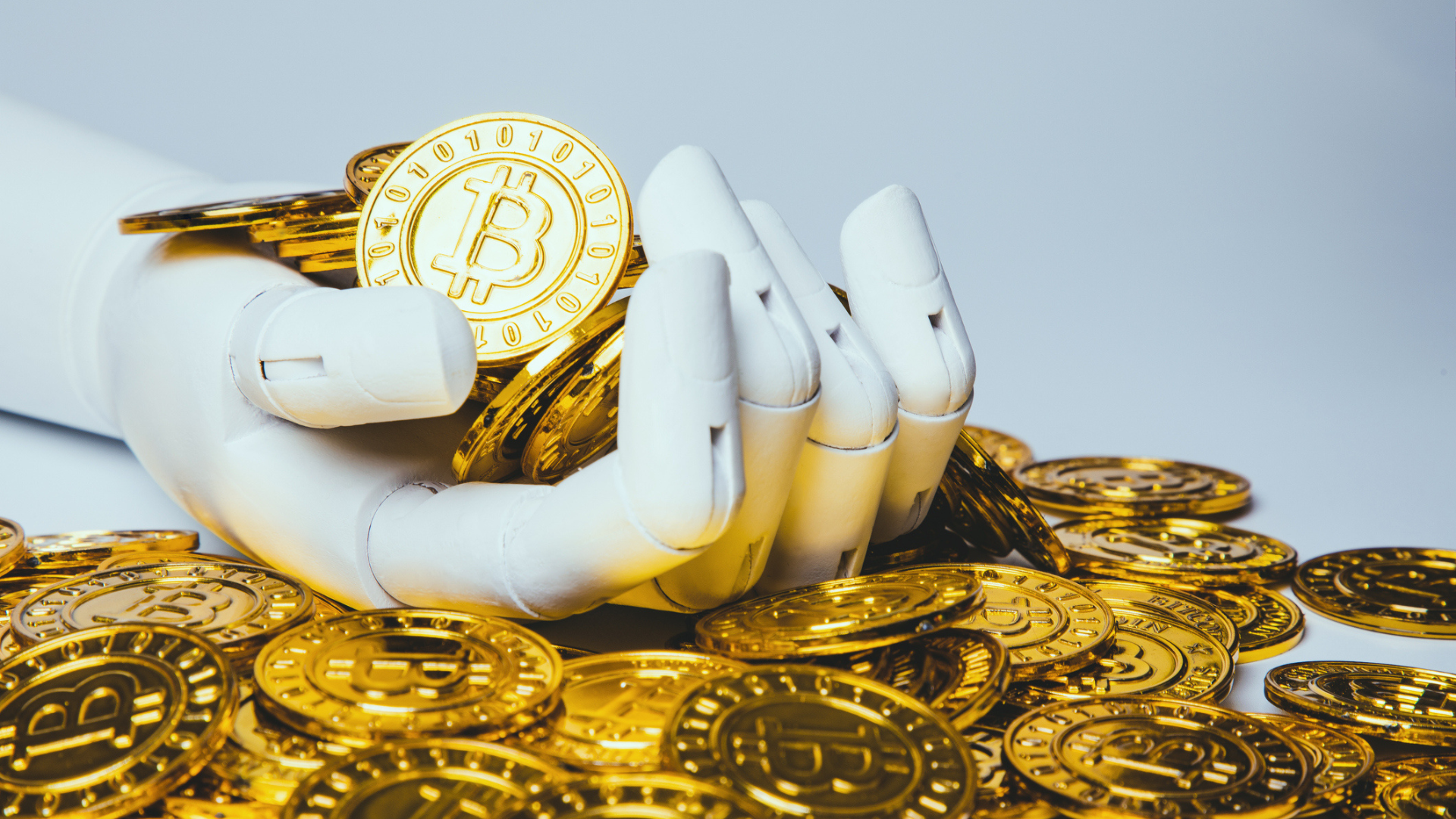 Robotic hand holding bitcoin - stock photo