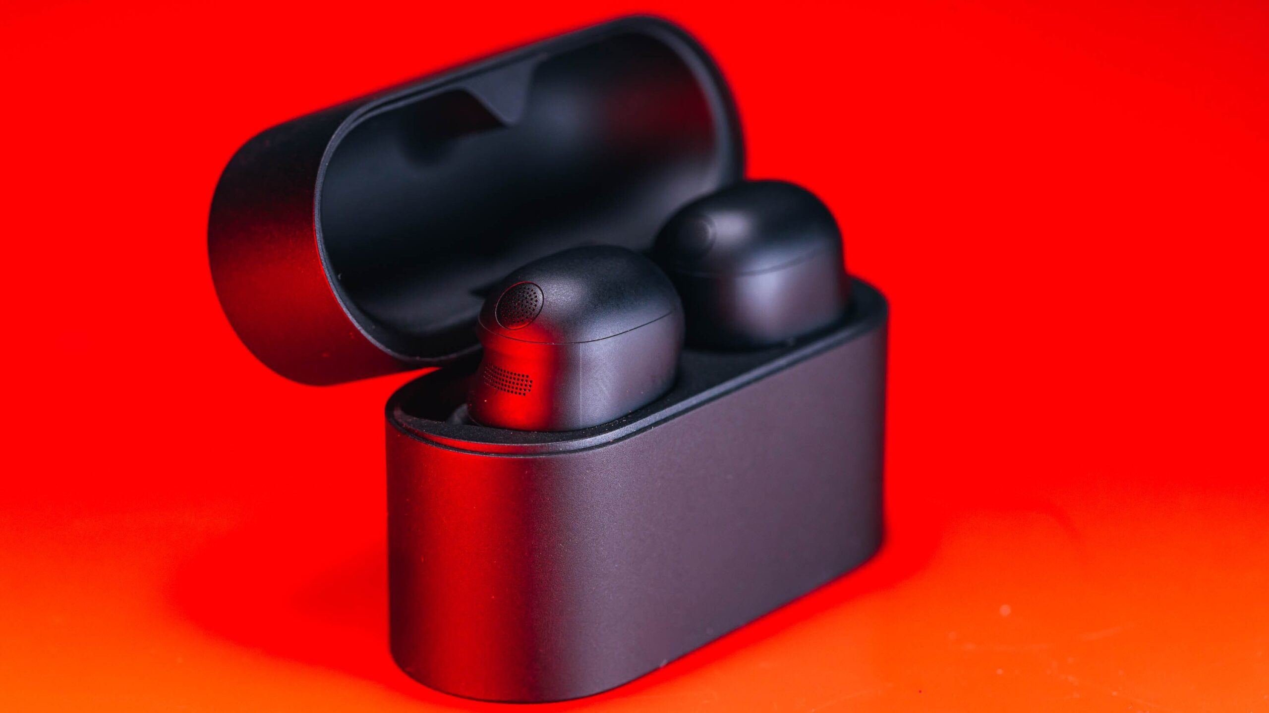 sony xm6 earbuds in charging case on red background