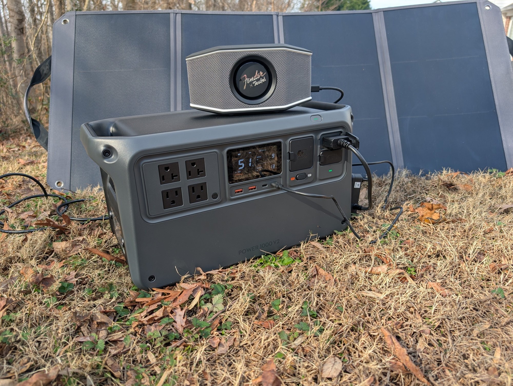 the DJI Power 1000 V2 outside powering a portable speaker with a solar panel behind it