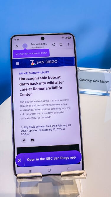 holding the s26 ultra with news on screen