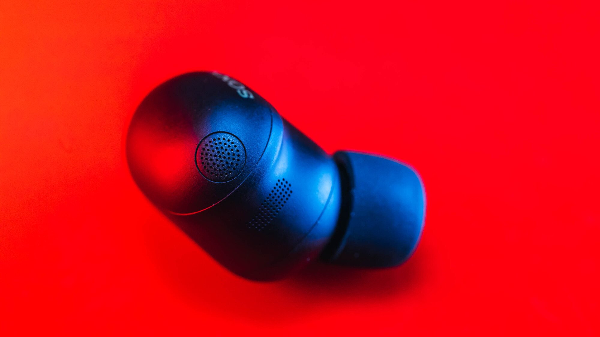 close-up portrait of sony xm6 earbuds on red background
