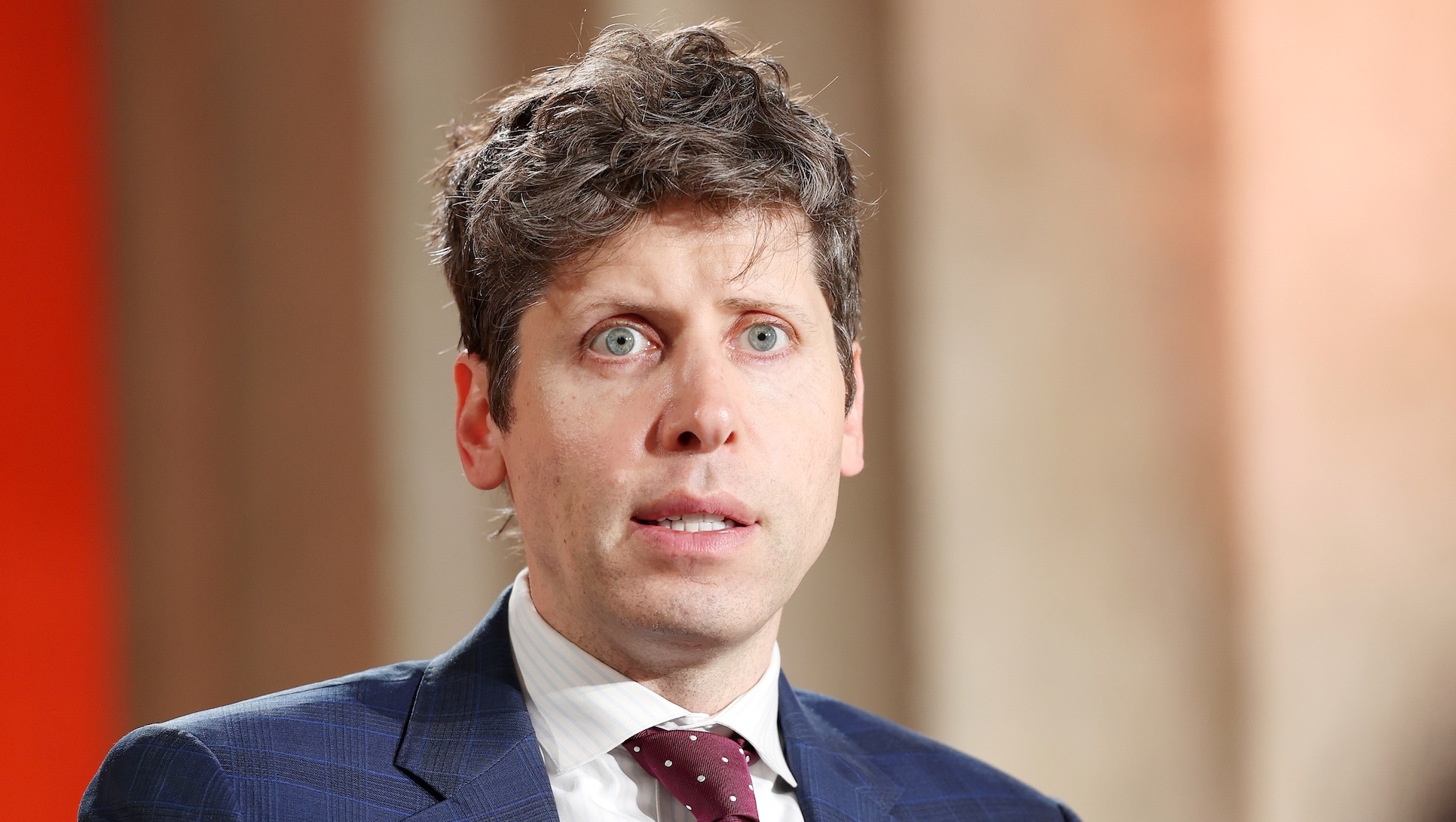 Sam Altman in suit and tie, looking stunned.