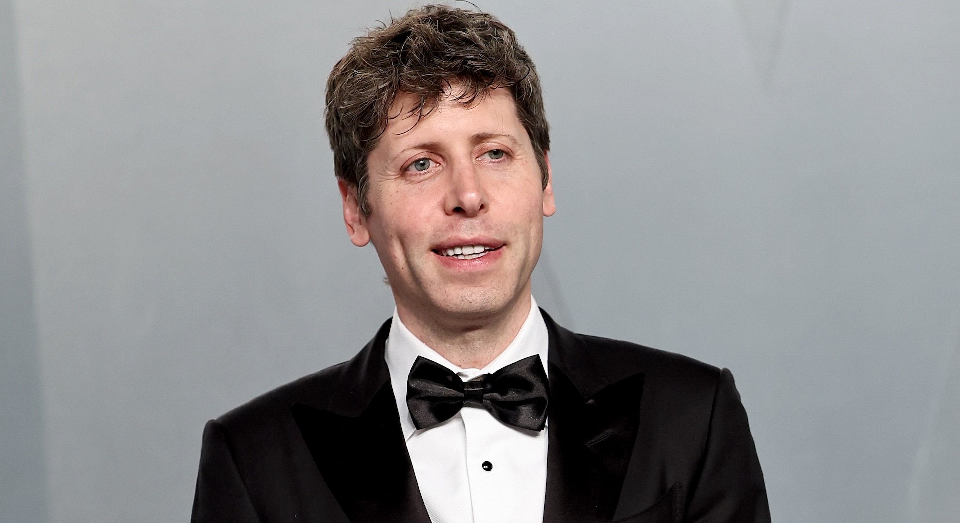 Sam Altman grimaces in a tuxedo.