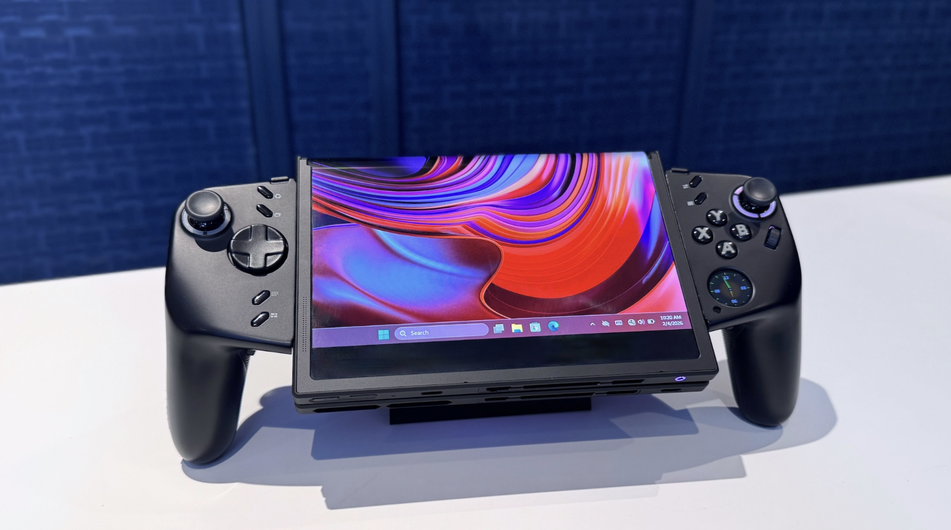 A handheld gaming system with a foldable central display.