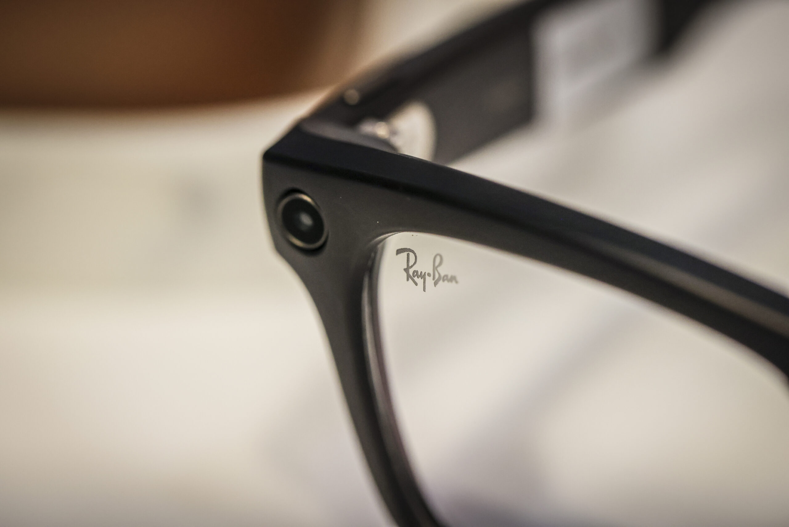 A close-up image of a small camera in the corner of the Ray-Ban Meta glasses frame.