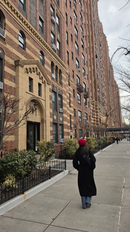 a woman in a red beret walks in new york city
