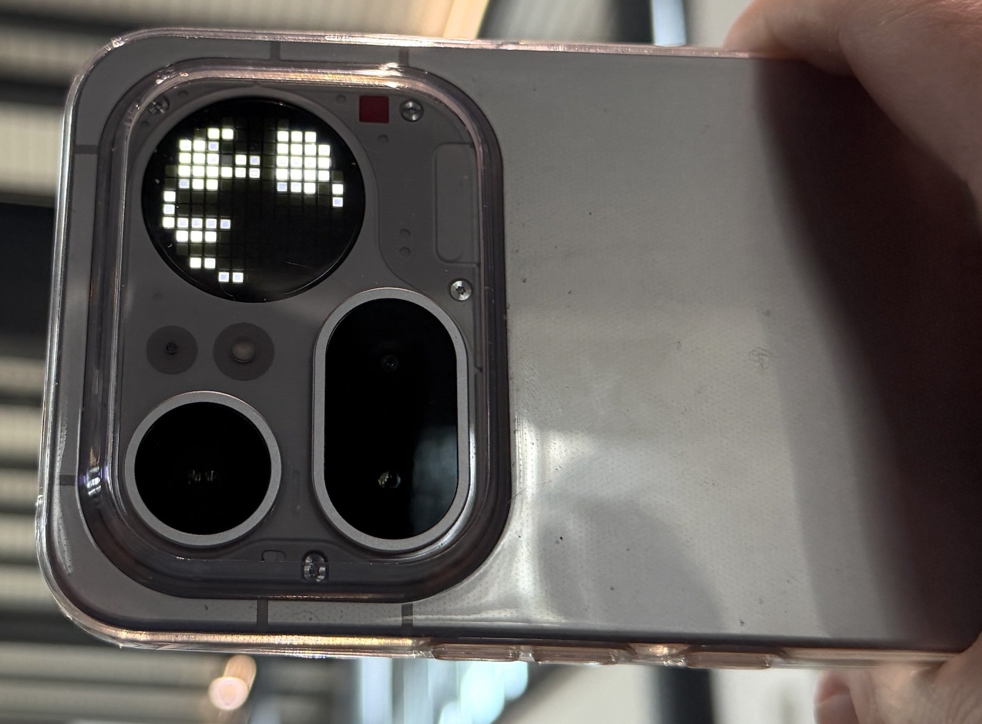 The back of the Nothing Phone with a small circular screen featuring pixels