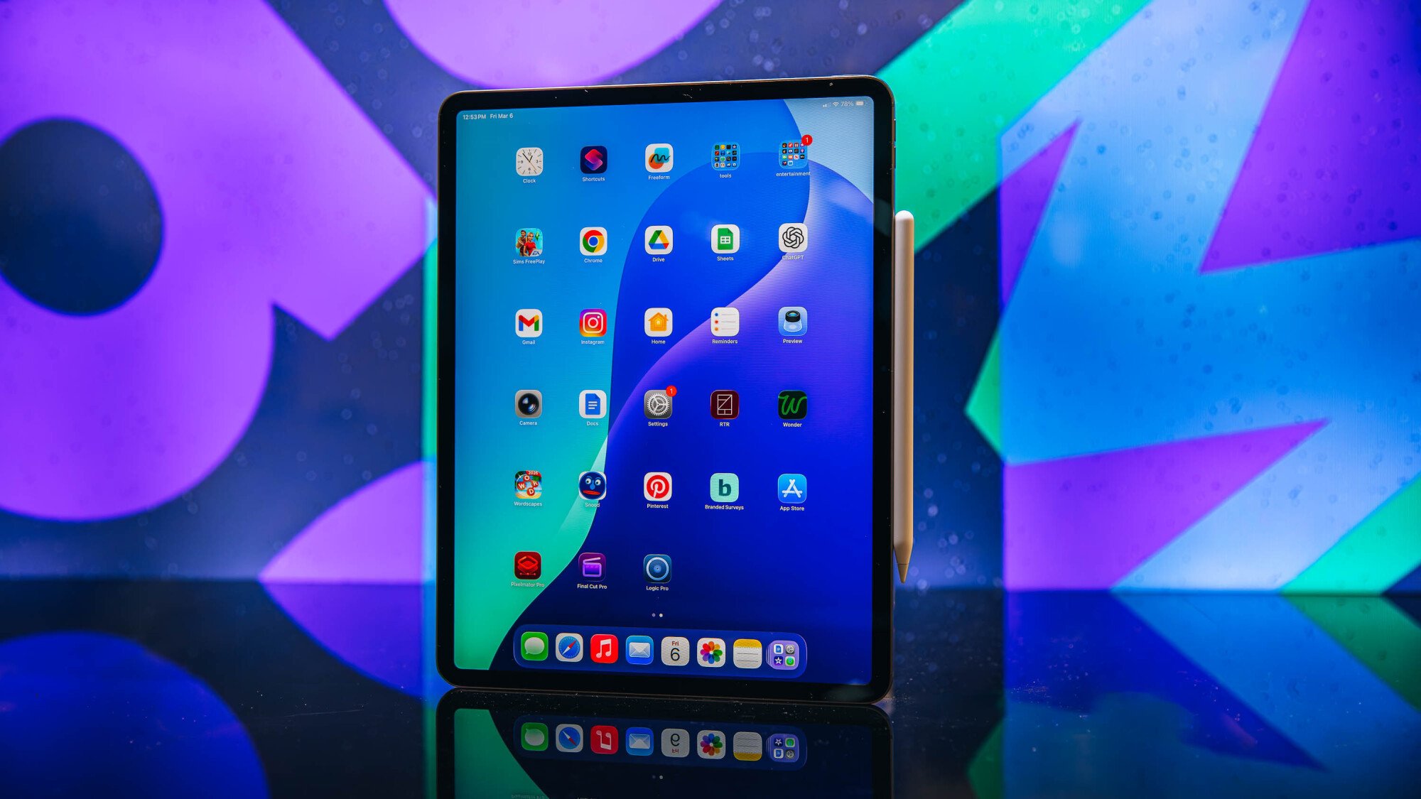 13-inch iPad Air with Apple Pencil, sitting on a table with a colorful background.