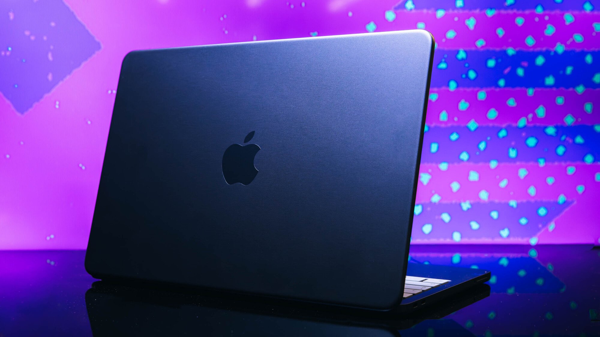 macbook neo in indigo color posed on purple background