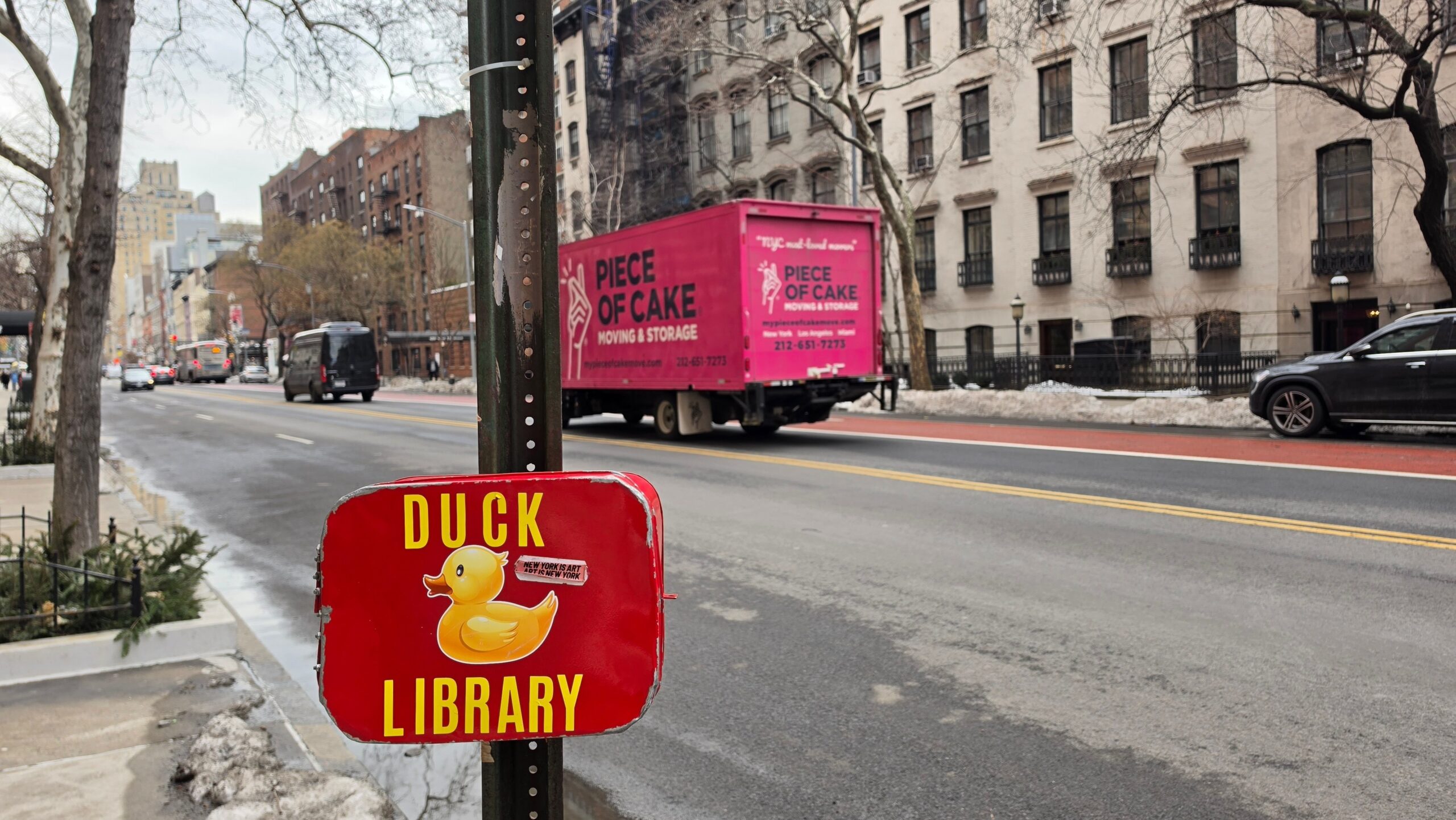 photo of new york city street with passing moving truck