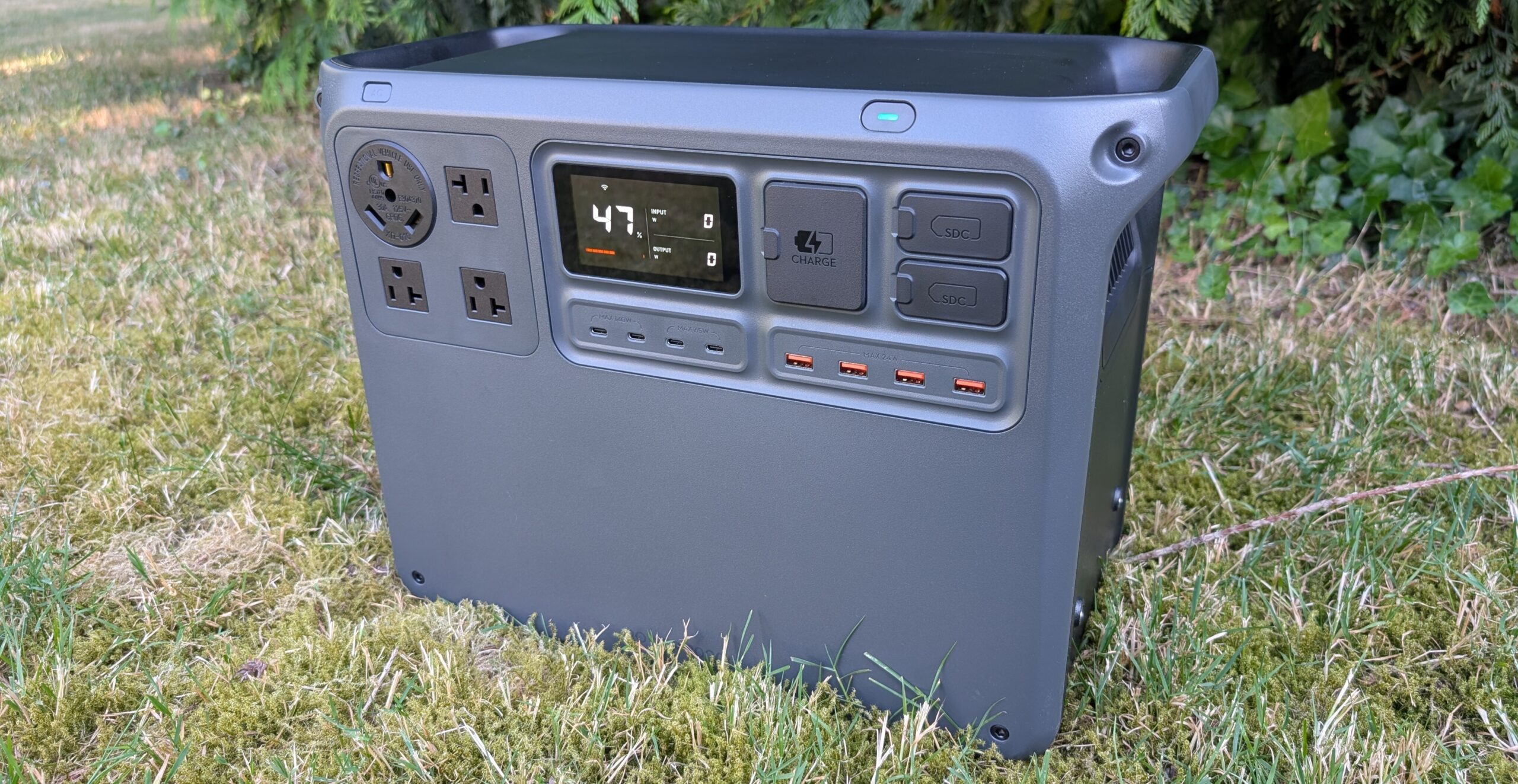 the dji power 2000 portable power station sits outside in brown grass