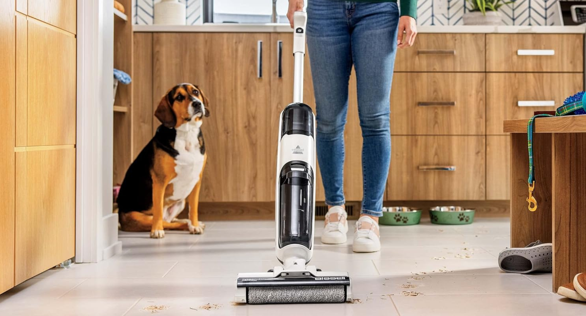 A woman using the Bissell TurboClean Cordless Hard Floor Cleaner Mop and Lightweight Wet/Dry Vacuum.