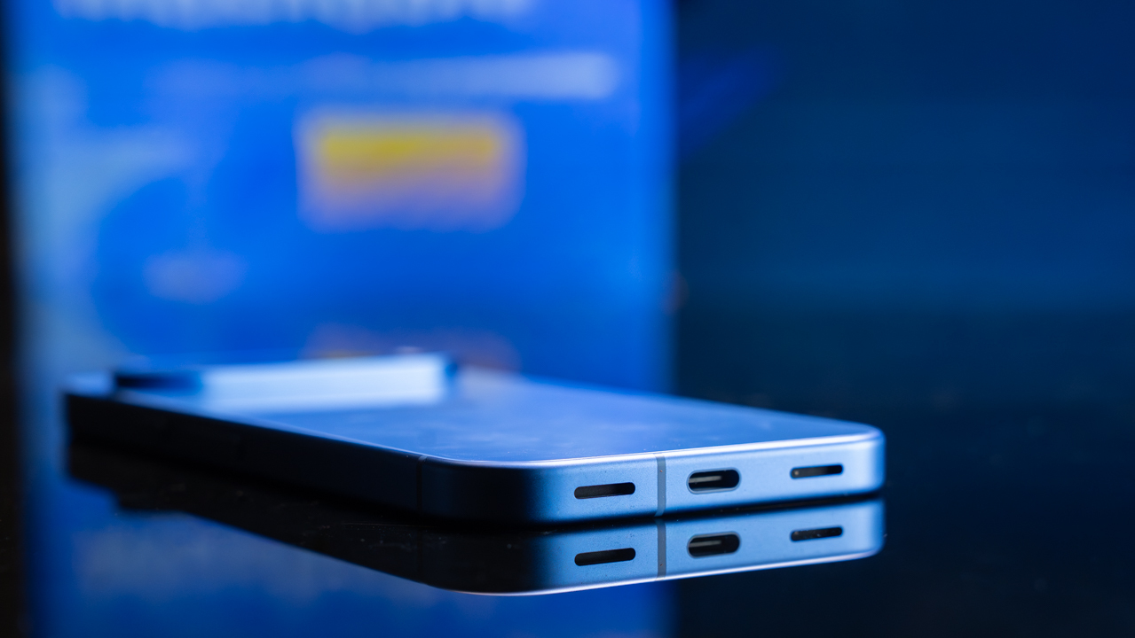 A smart phone laying flat on a reflective table. 