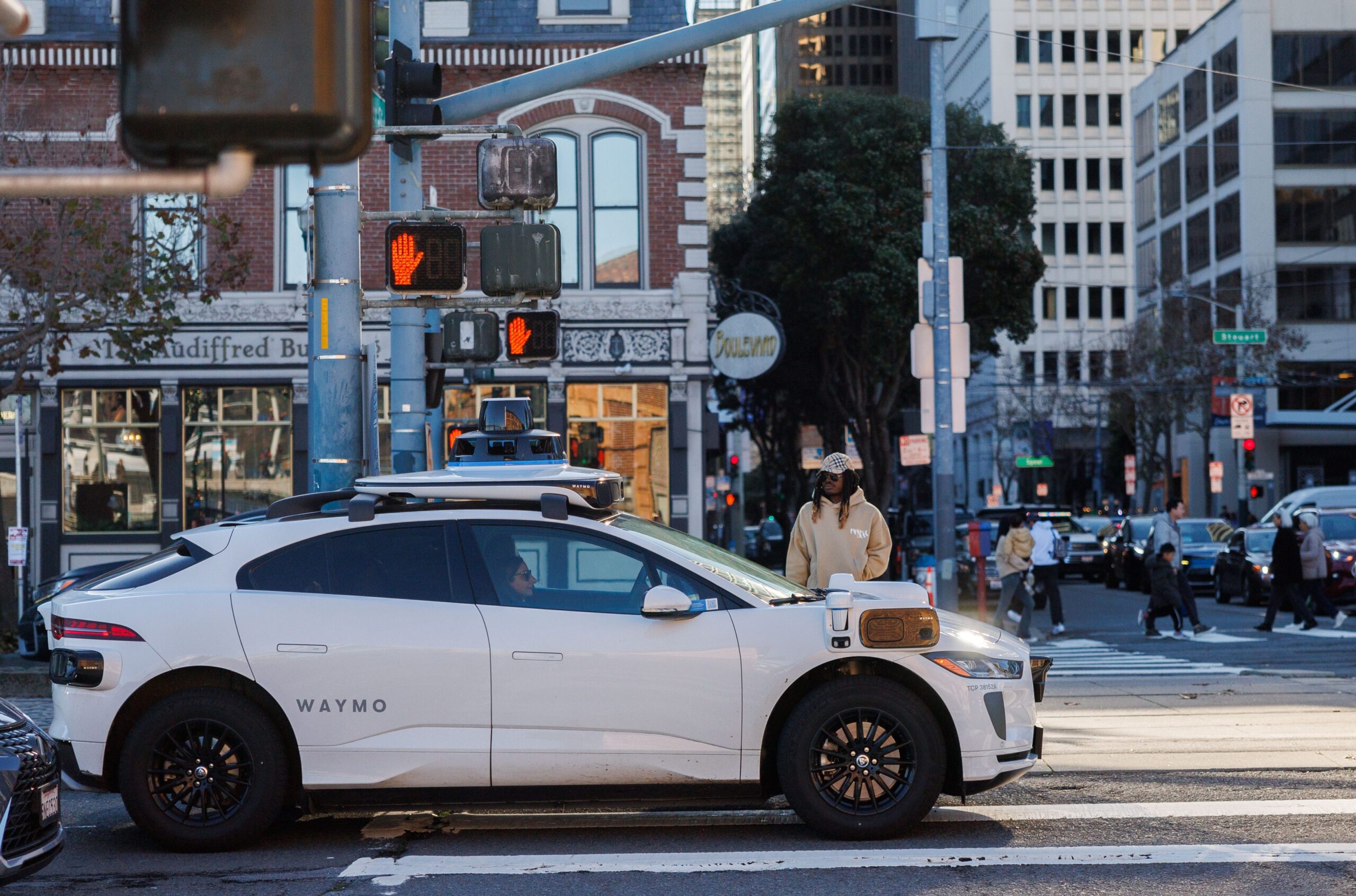A white Waymp vehicle waiting at a Chicago intersection.