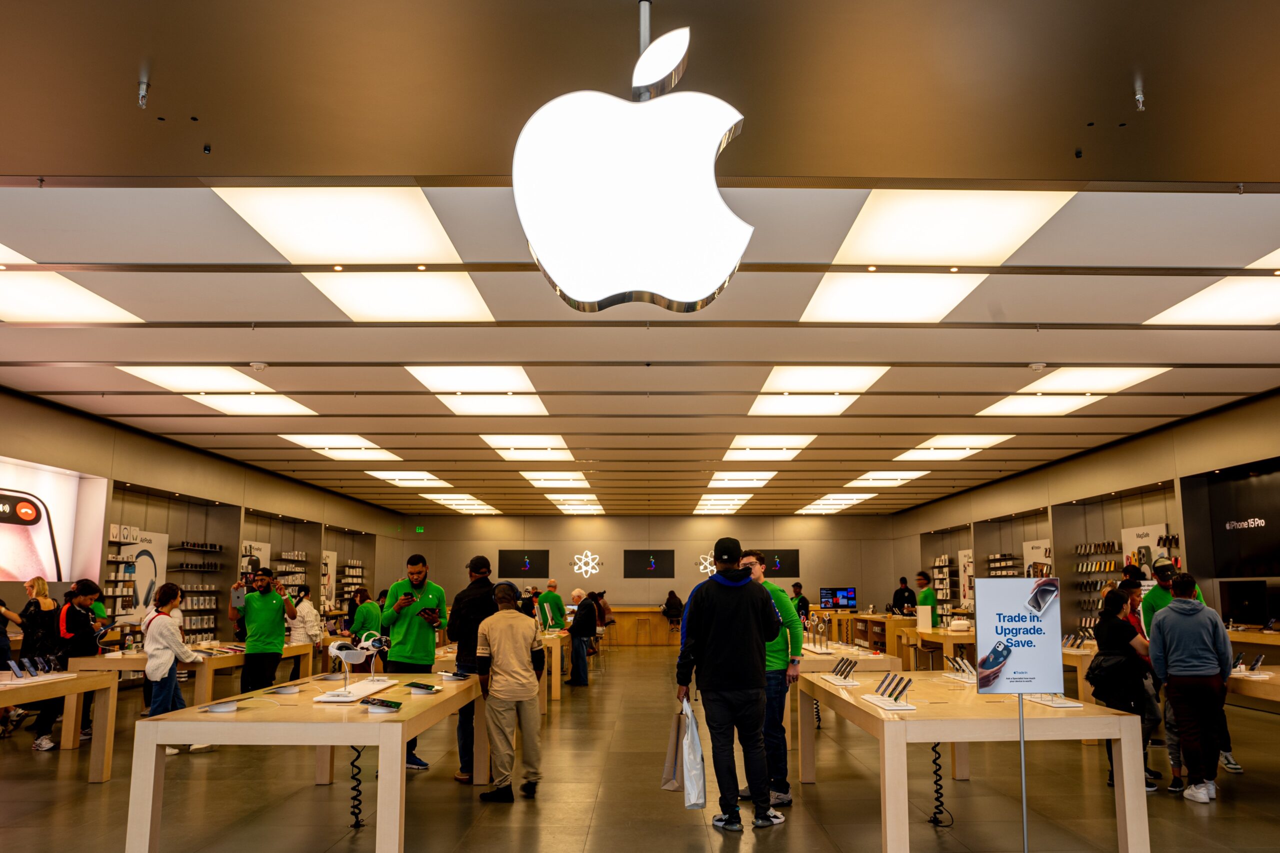 The entrance of an Apple store, with a glowing Apple logo sign above. 