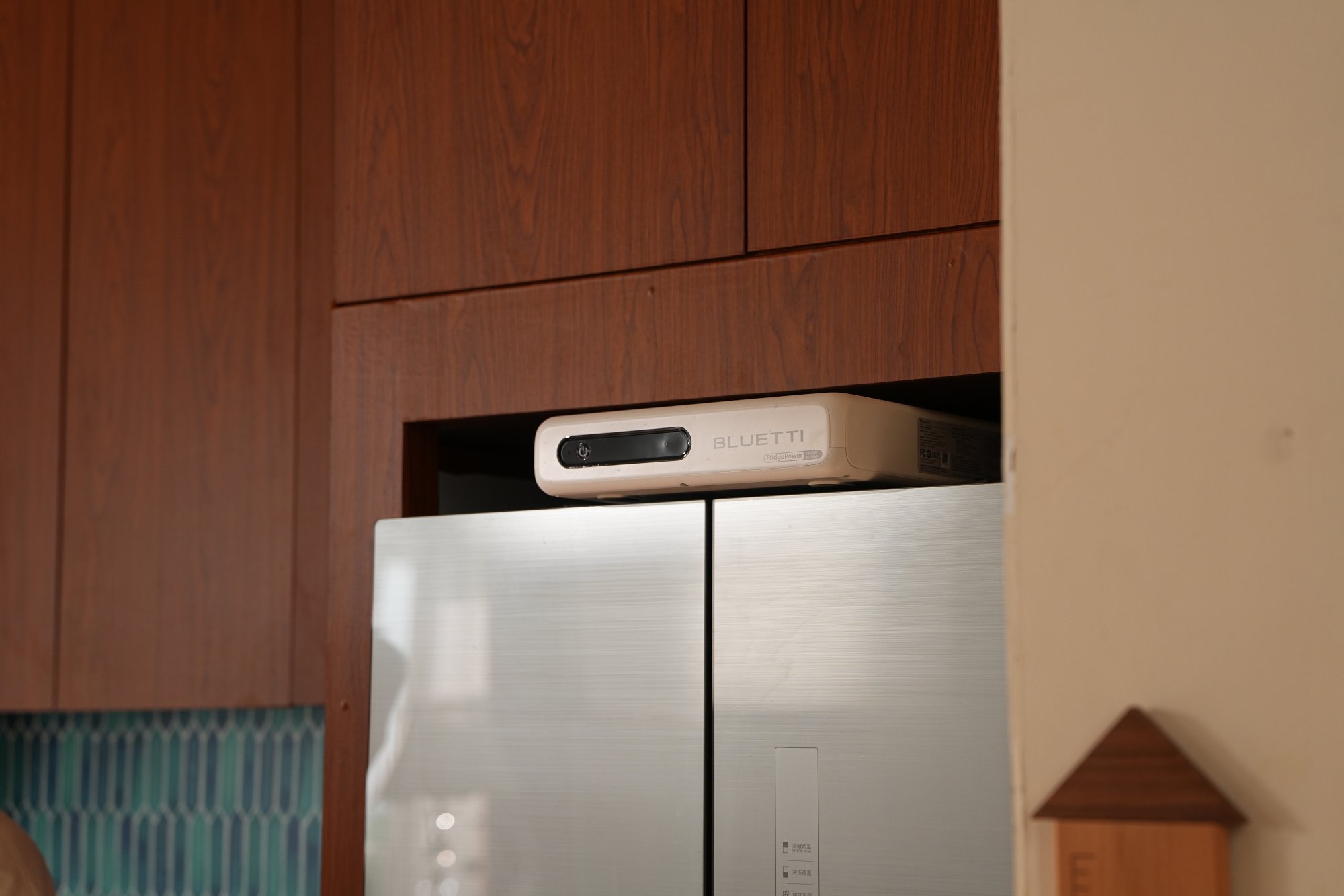 the bluetti fridgepower sits above a fridge