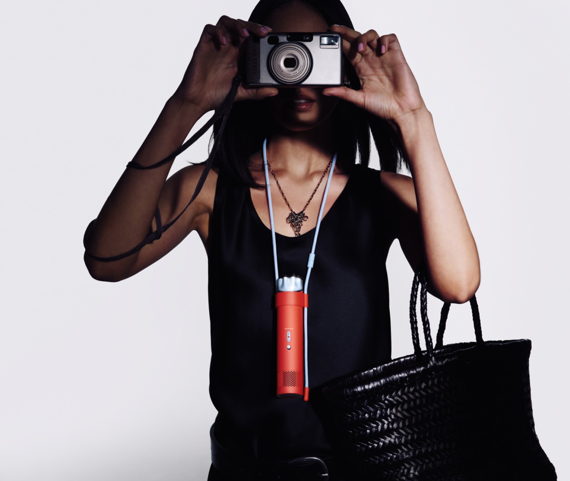 a woman wearing the dyson hushjet mini cool around her neck while taking a picture