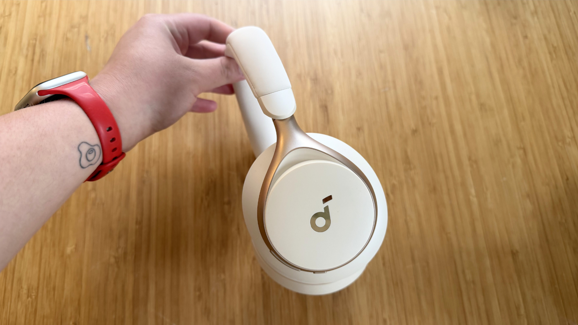 A hand holding up the Soundcore Space One headphones