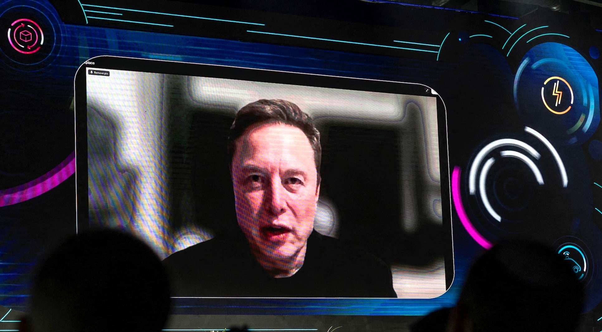 Elon Musk on giant screen surrounded by neon lines