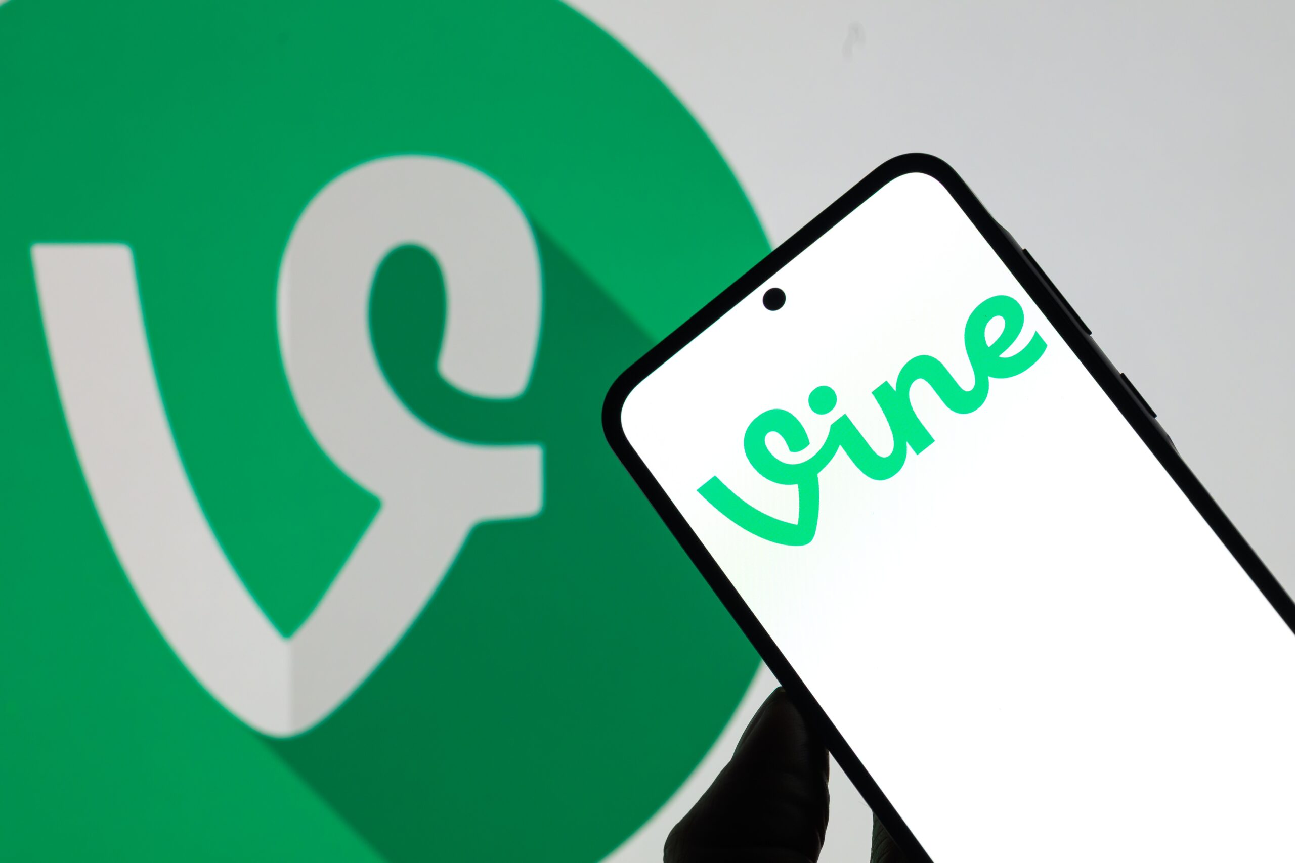 The Vine logo is displayed on a mobile phone with the Vine icon