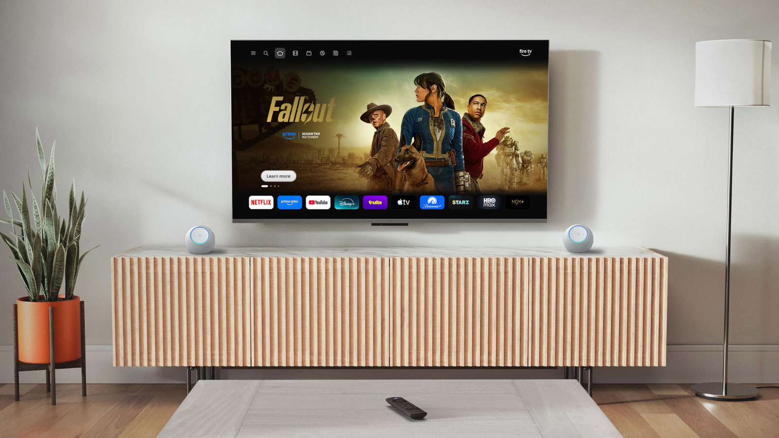Fire TV Stick 4K Max laying on coffee table in living room with Prime Video on TV