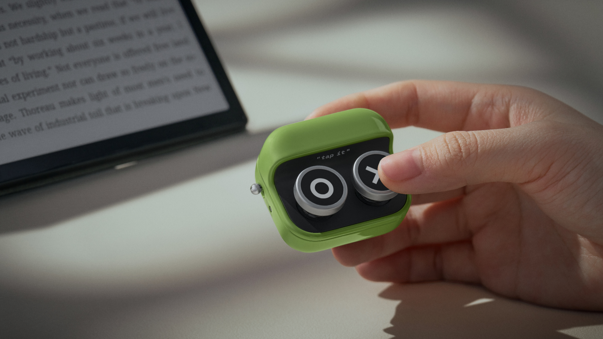 A hand holding the Boox Tappy remote